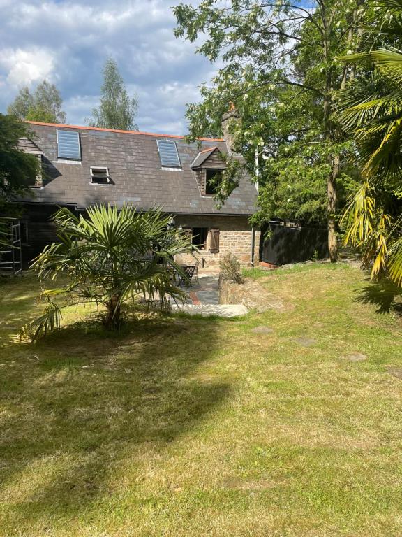 a house with a tree in front of it at La Bruyere in Saint-Pois