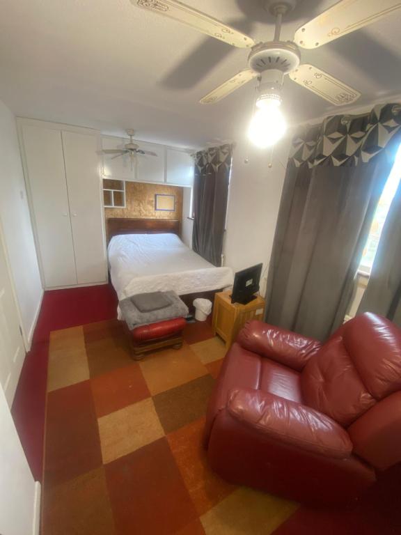 a bedroom with a bed and a couch at A Spacious Odyssey in Dagenham