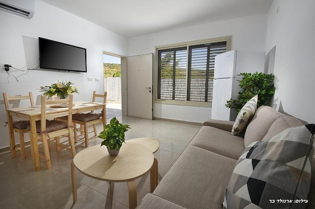 a living room with a couch and a table at MeravSuite in Migdal