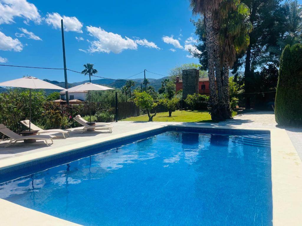 a swimming pool with chairs and a house at B&B Casa Ellie in Tormos