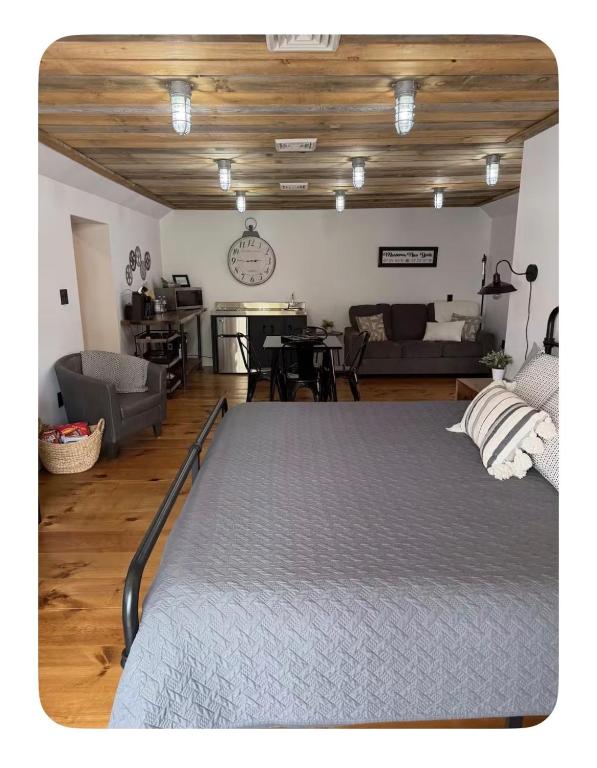 a bedroom with a large bed and a living room at Sleep at Simplicity in Massena