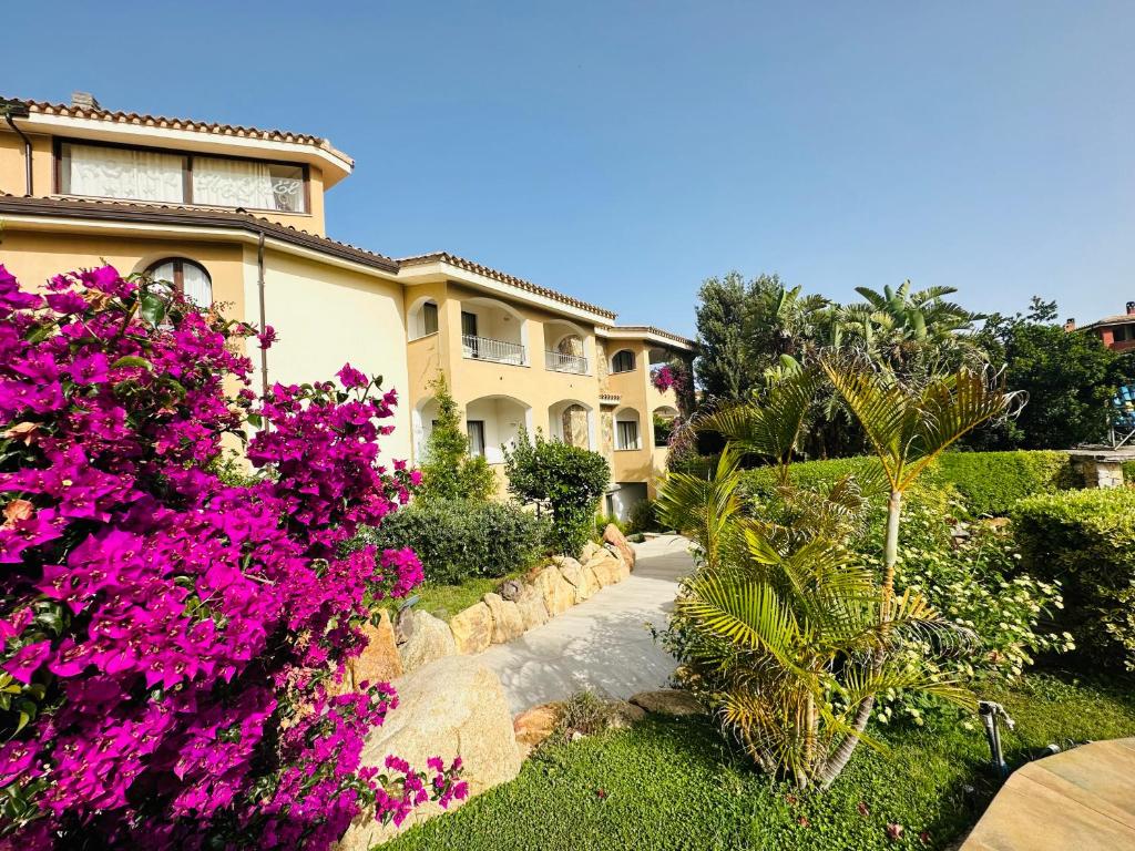 ein Haus mit rosa Blumen davor in der Unterkunft Hotel RaffaEl in Villasimius