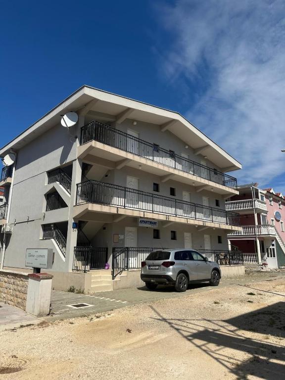 a building with a car parked in front of it at MAAR Kovačić Apartmani in Zaton