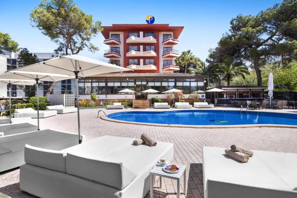 a hotel with a pool with white furniture and a building at Hotel Pabisa Chico in Playa de Palma