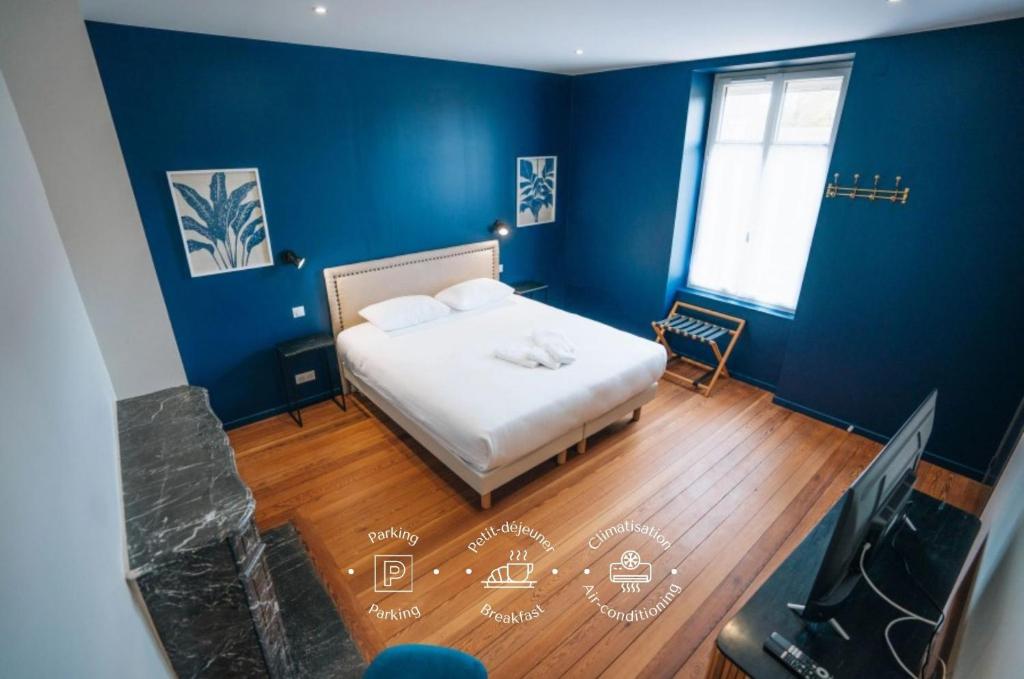 a blue bedroom with a bed and a television at La Marjolaine - Demeure d'Hotes - Service Para-hôteIier - Premium in Châteauroux