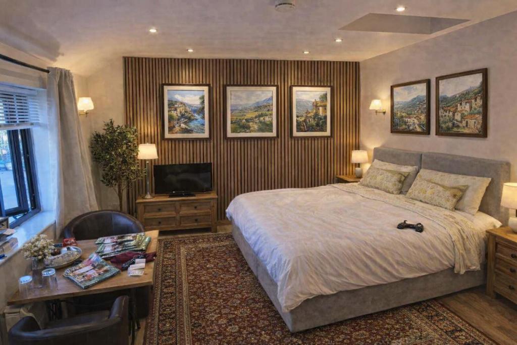 a bedroom with a bed and a desk and a television at Miltons Apartments and Rooms in Langford