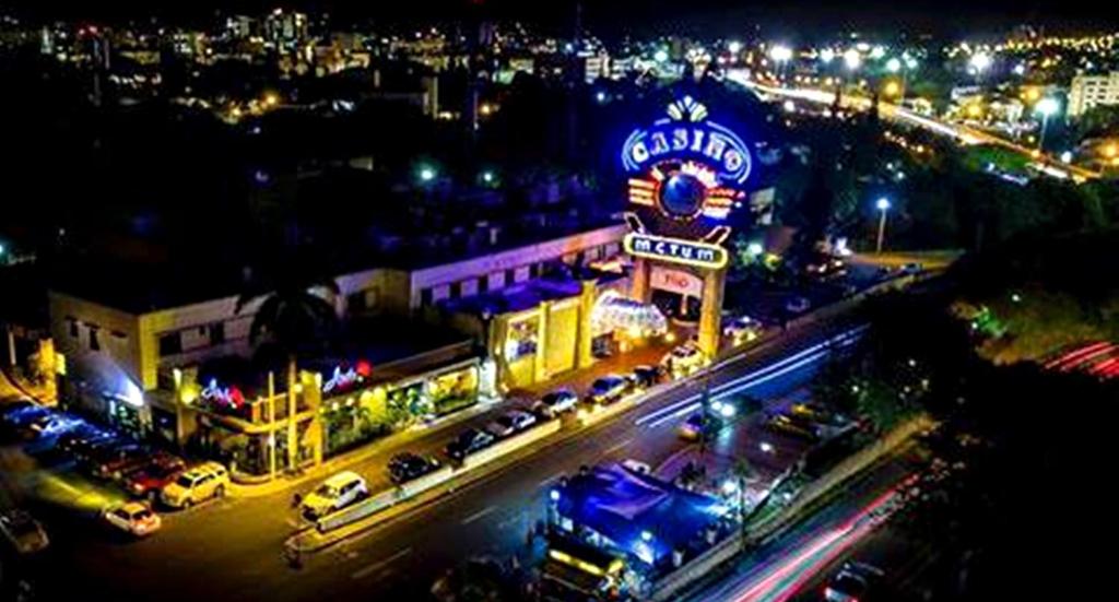 Una ciudad de noche con coches aparcados frente a un motel en Matum Hotel & Casino, en Santiago de los Caballeros