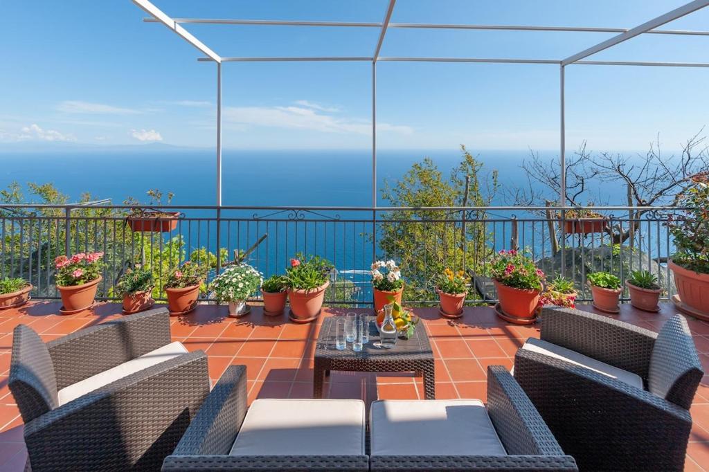 a balcony with chairs and a table and some plants at La casa del sole in Conca dei Marini