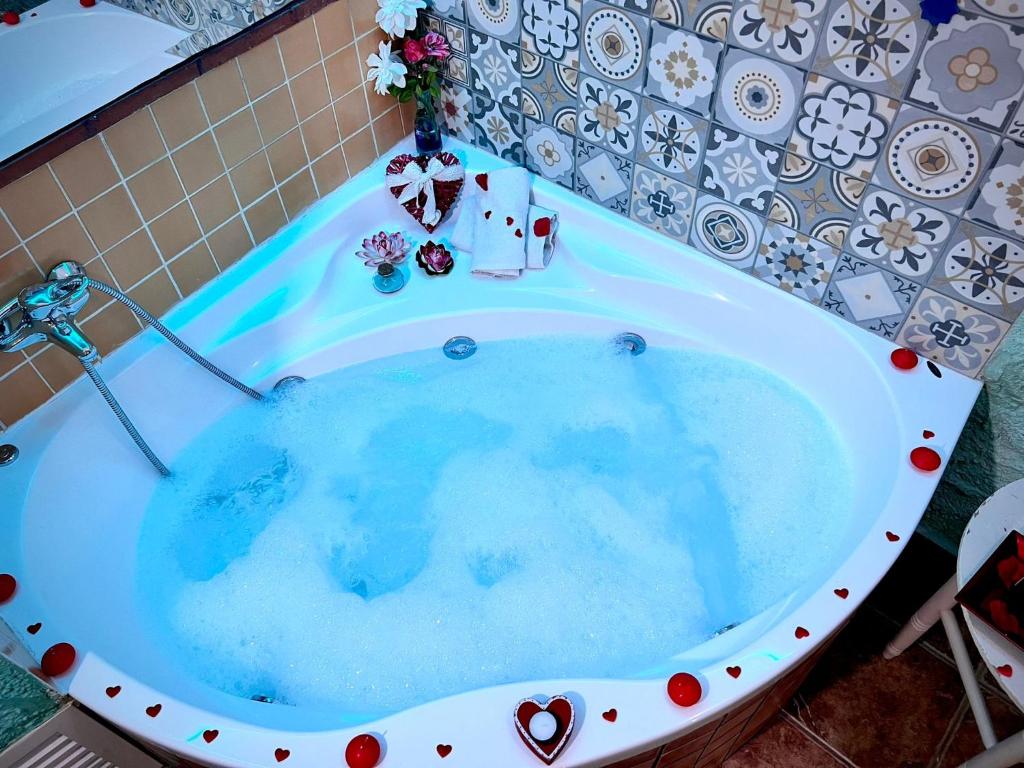 a bath tub filled with blue water in a bathroom at Cueva La Panadera - CuevasCazorla in Hinojares
