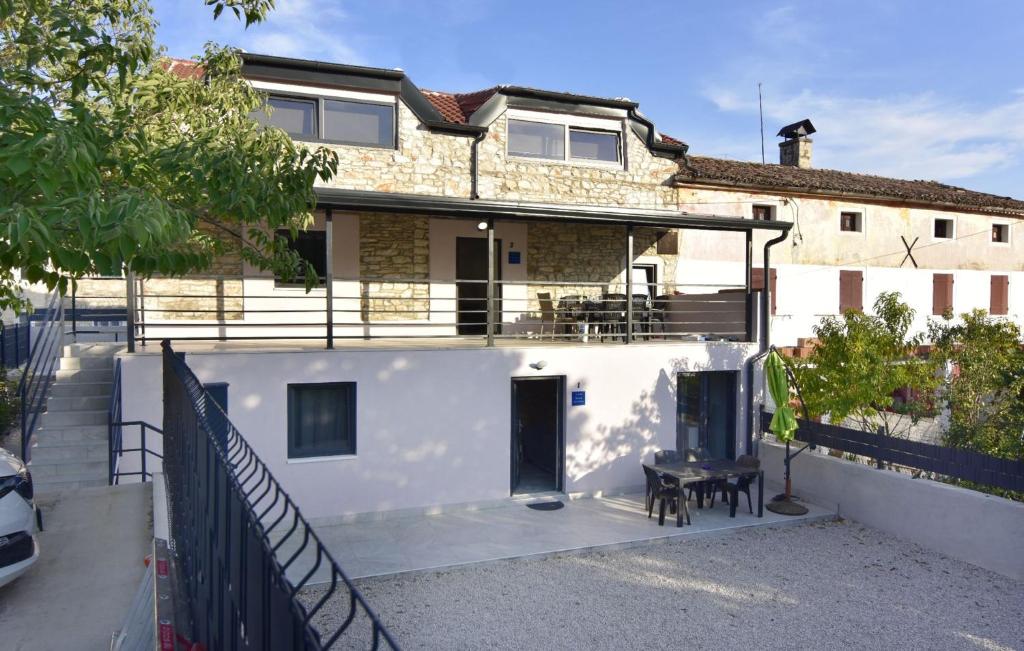 a white house with a balcony and a fence at Comfortable vacation retreat with parking in Plovanija