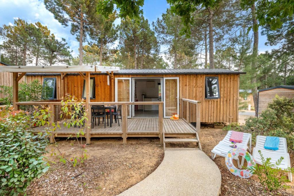 a tiny house in the woods with a deck at Camping El Canto la Gallina in Valdemaqueda