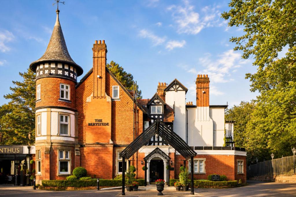 an old red brick building with a turret at Macdonald Berystede Hotel & Spa in Ascot