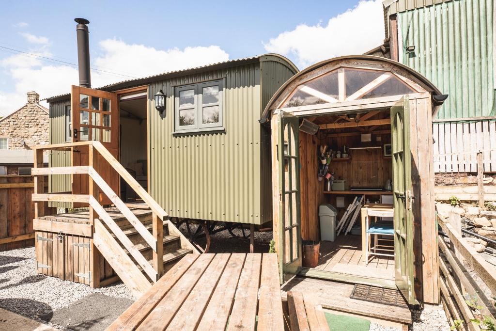 a green shipping container with an open door and a wooden deck at Willows in Rosedale Abbey