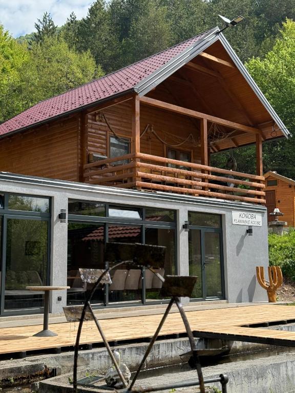 a house on a dock with a large deck at Planinske kolibe Šipovo 3 in Šipovo