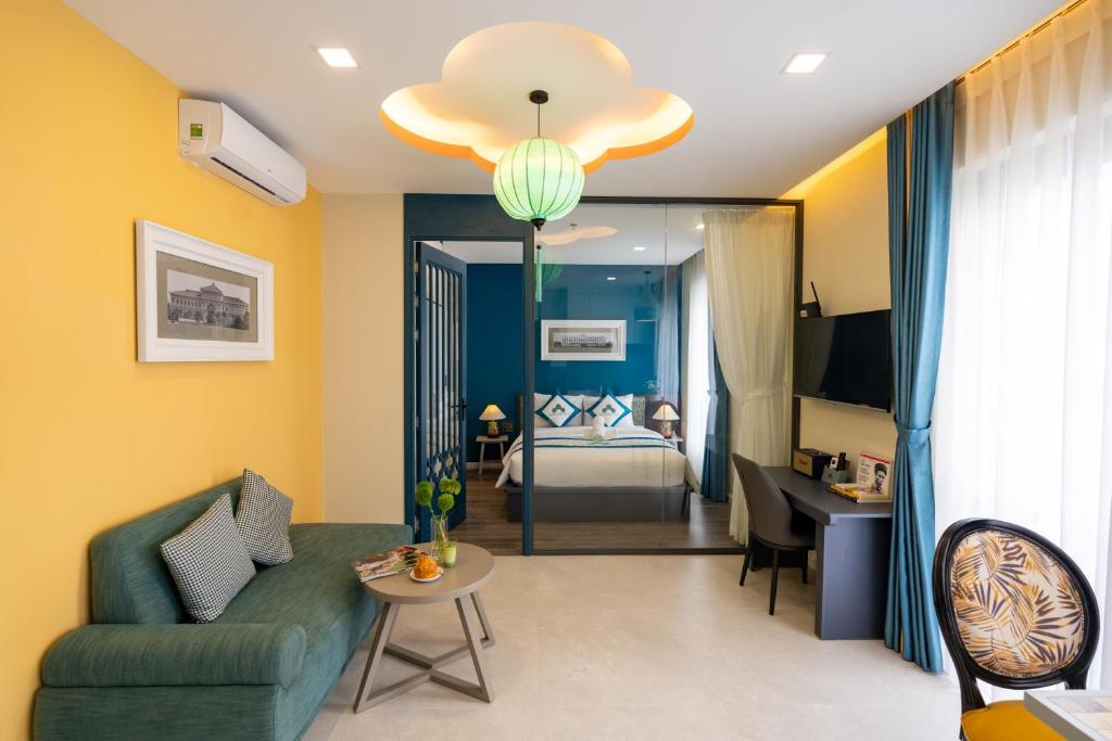 a living room with a couch and a room with a bed at Indochine Casa Hotel in Ho Chi Minh City