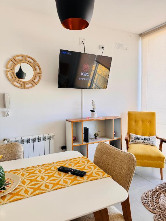 a living room with a table and a tv on the wall at Los Pirineos TC in Junín