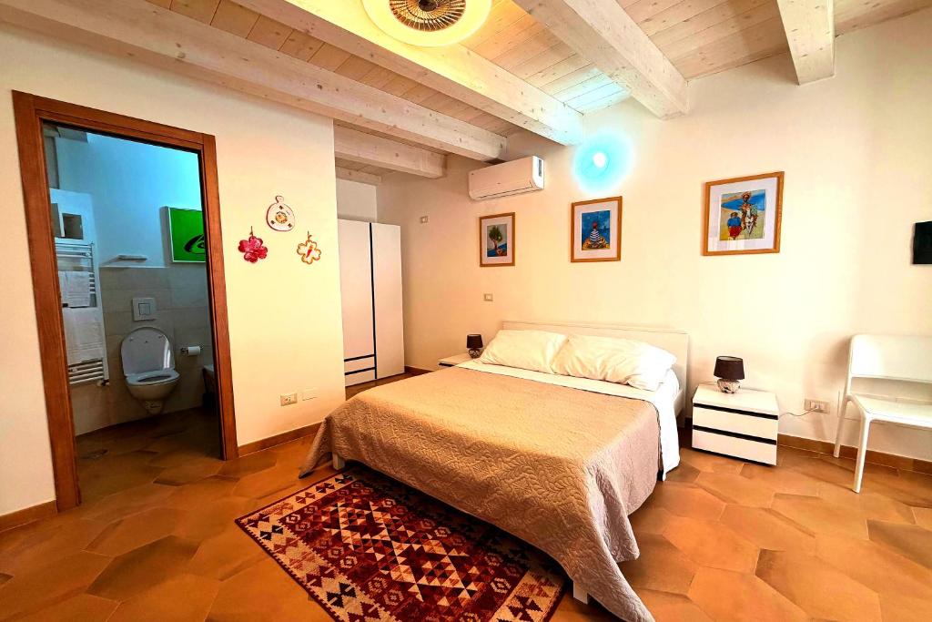 a bedroom with a bed and a bathroom with a toilet at Your Charming Amantea Getaway in Amantea