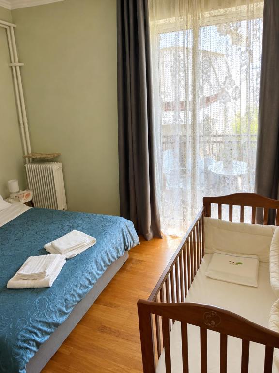 a bedroom with a crib and a large window at Pinetree House in Nafplio