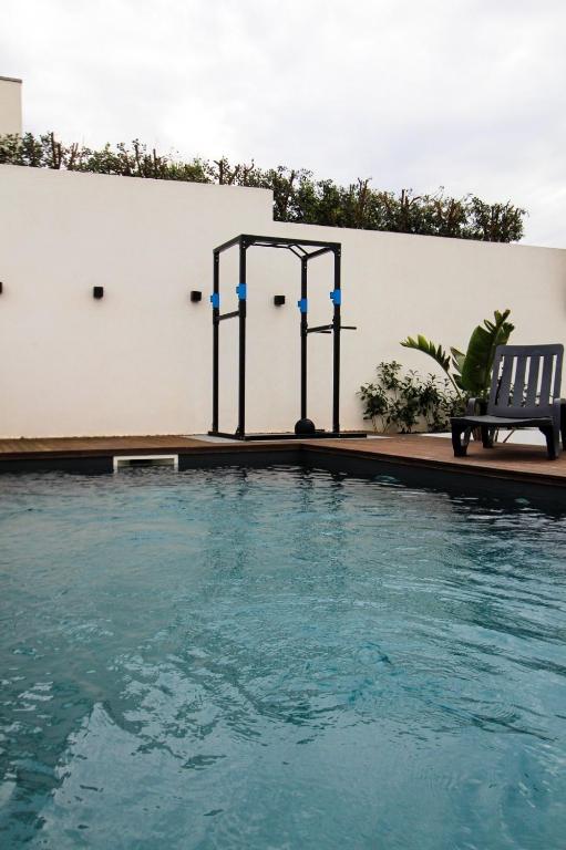 a swimming pool with a bench next to a building at Private Beach Villa in Vila Nova de Gaia