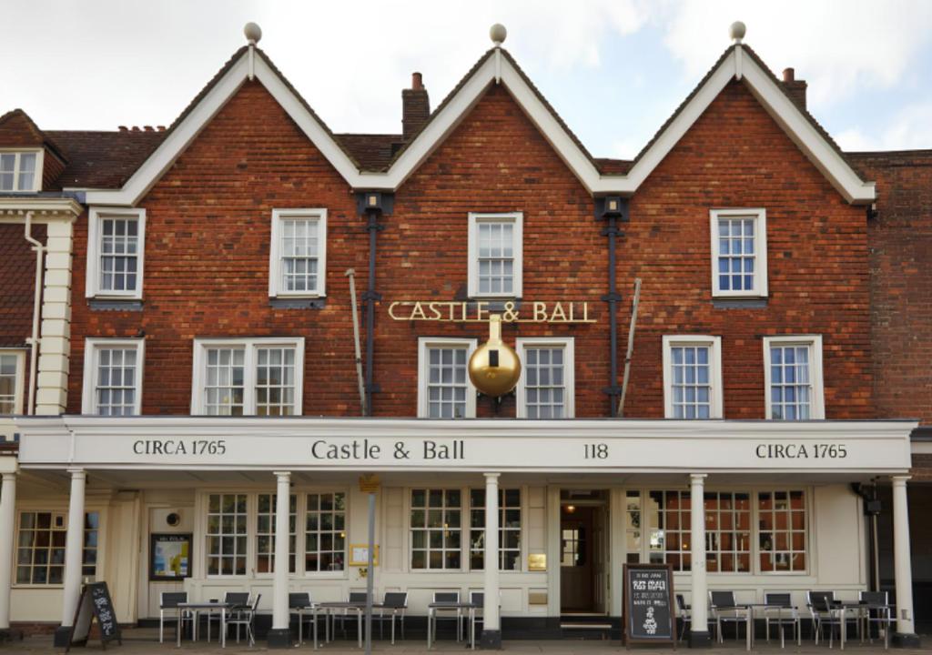 a red brick building with a sign that reads castle and ball at Castle and Ball by Greene King Inns in Marlborough