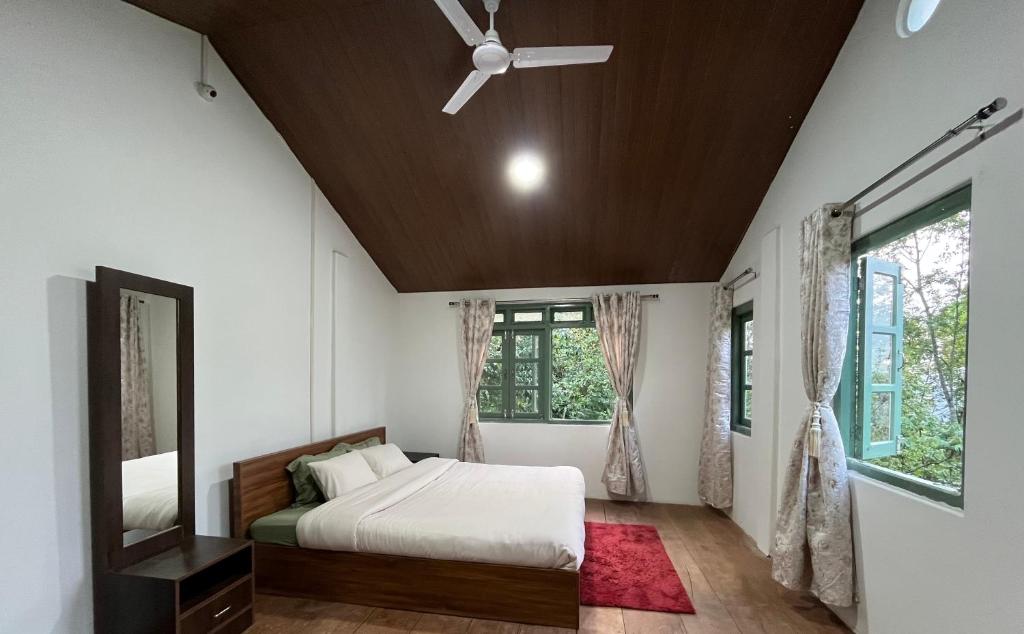 a bedroom with a bed and a ceiling fan at Chara Farmhouse in Kohīma