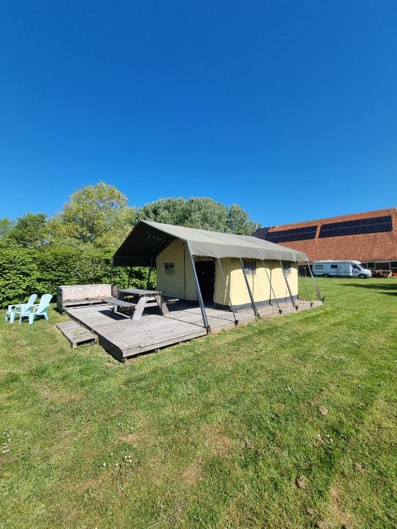 a tent with a picnic table in a field at Safaritent Aesgestate in Gauw