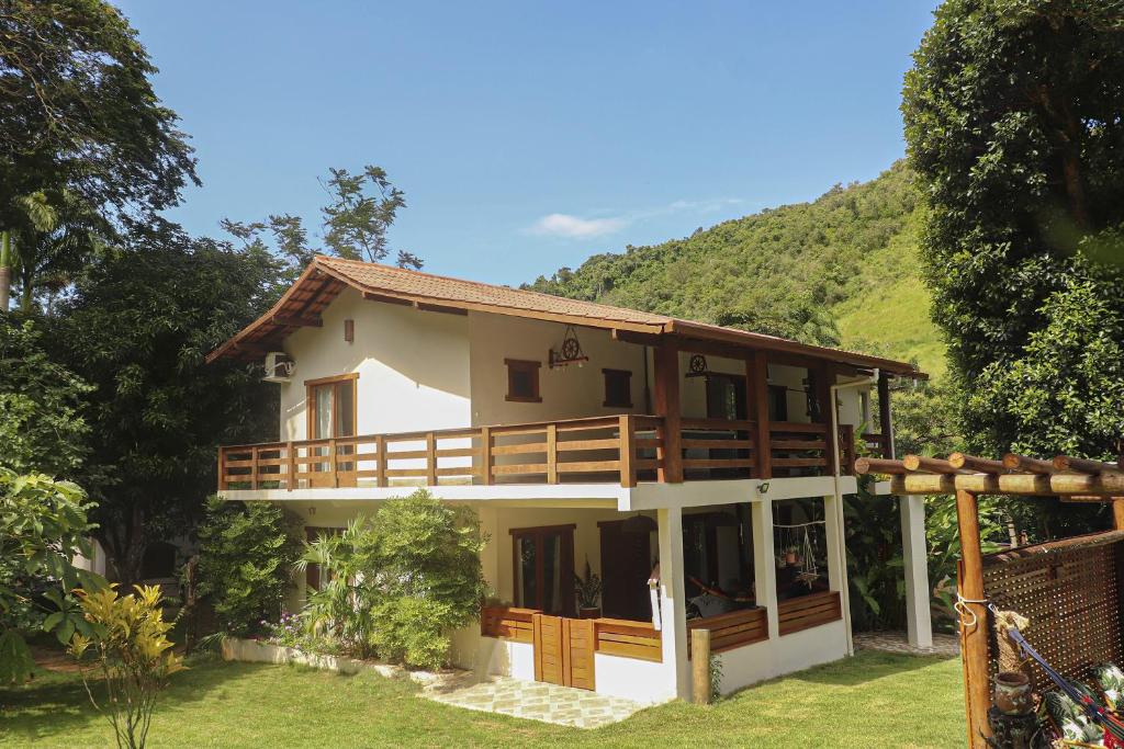 a house with a mountain in the background at Hospedagem Arte na Cura in Guarapari