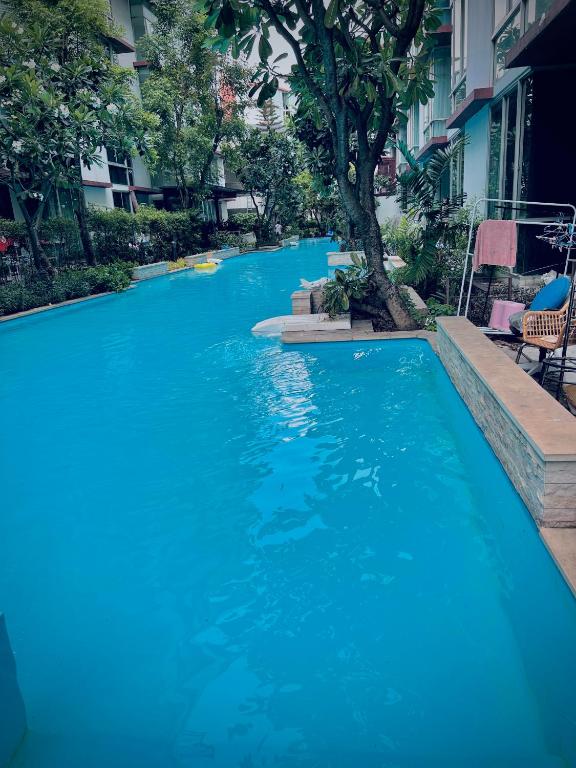 a swimming pool with blue water in a building at Cozy Poolside Condo Near BTS All Amenities in Sathani Ban Hua Mak
