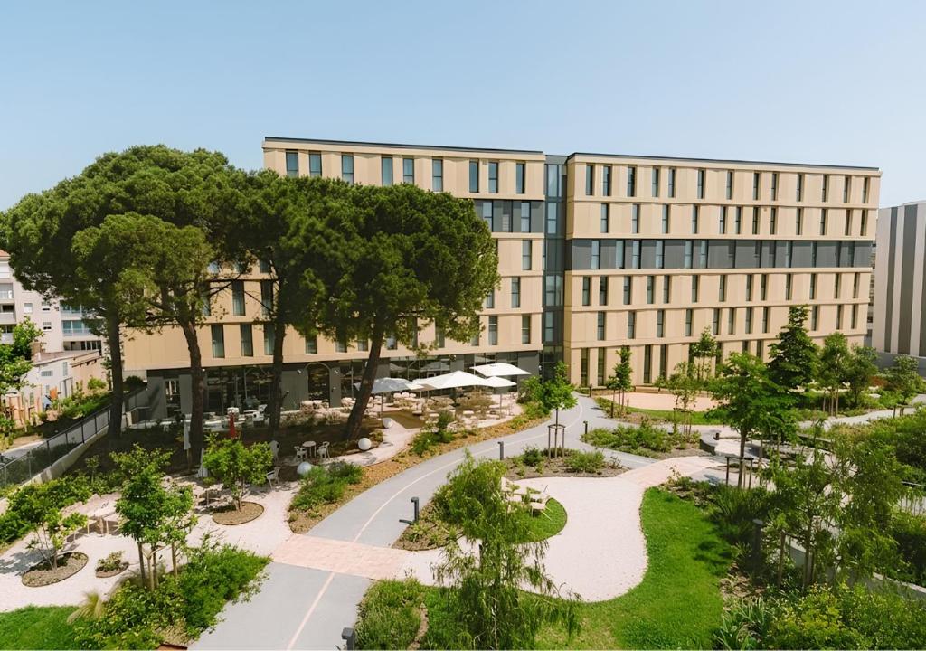 a building with a garden in front of it at Bikube Coliving Hôtel - Montpellier Centre Gare St Roch in Montpellier