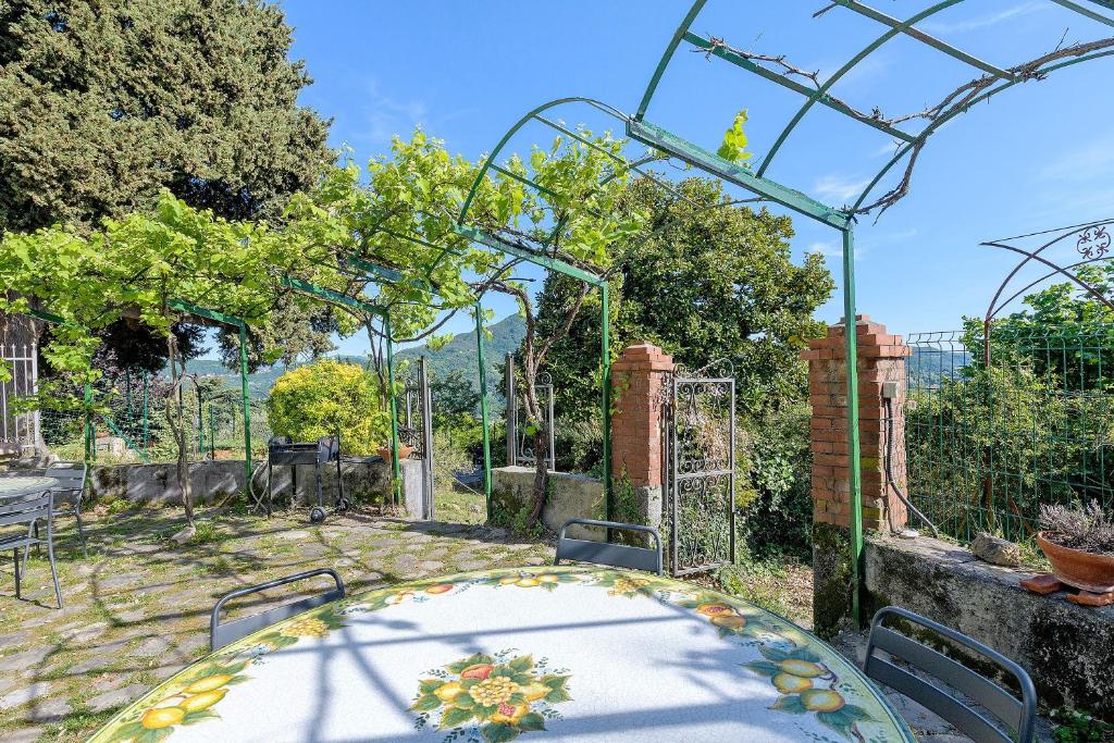 a table in a garden with an arbor and a patio at Villa Ponzio in Genoa