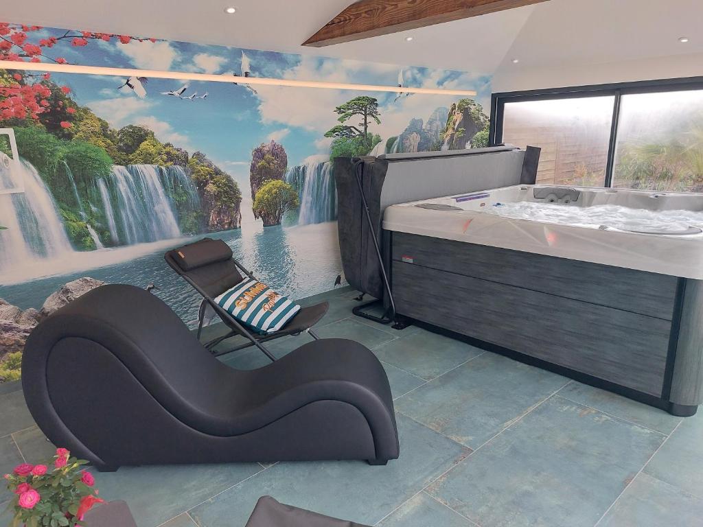 a room with a bath tub and a chair with a waterfall mural at Ô Sens Jacuzzi et Massages in Challans