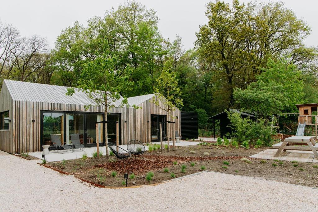 a small wooden house in the middle of a garden at Boshuis Haen in Ermelo