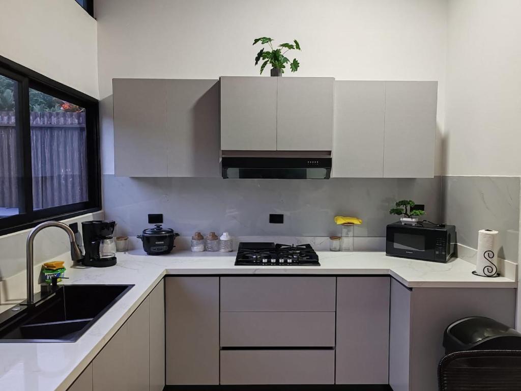 a white kitchen with a stove and a sink at Casa Congo Puerto Viejo in Puerto Viejo