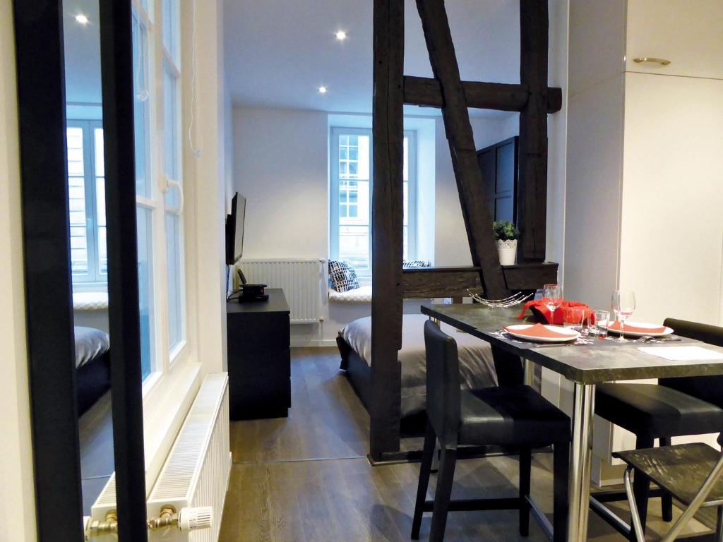 ein Esszimmer mit einem Tisch und Stühlen in einem Zimmer in der Unterkunft Appartement L'Ill au Sable in Straßburg
