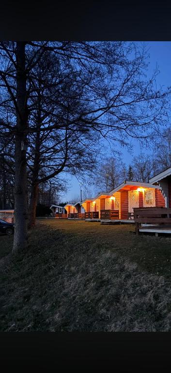 a park with a bench and a building with lights at Sikhall Camping & Restaurang in Sörbo