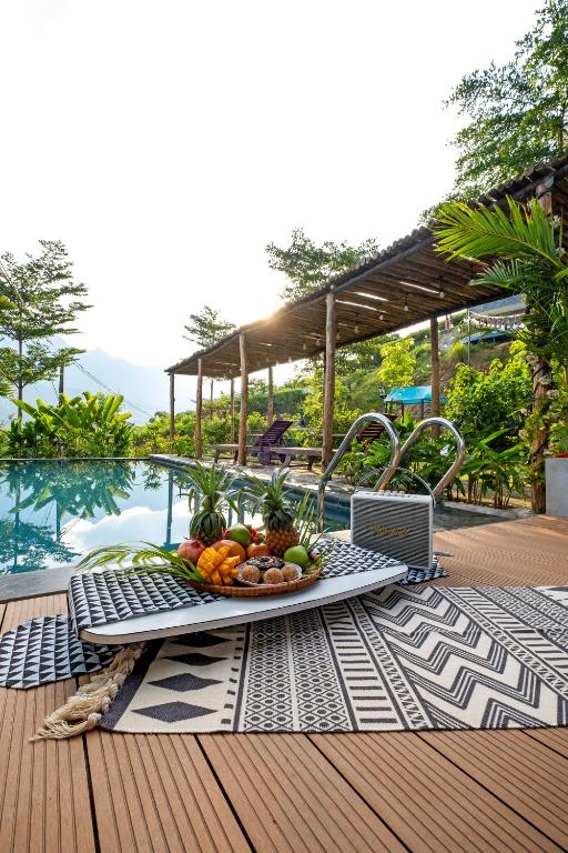 a tray of fruit on a table next to a pool at Greenfield Ba Vì - Nắng Villa in Yên Bài