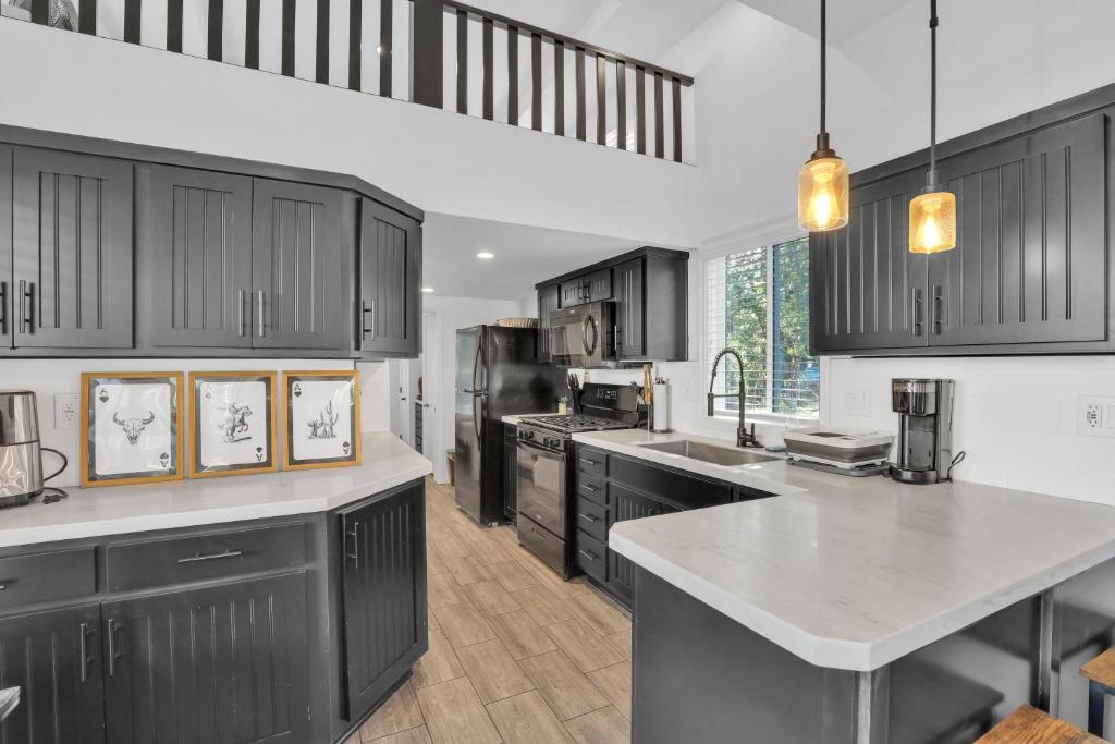 a kitchen with black cabinets and white counter tops at Tiny Blue at Yosemite Gateway in Groveland