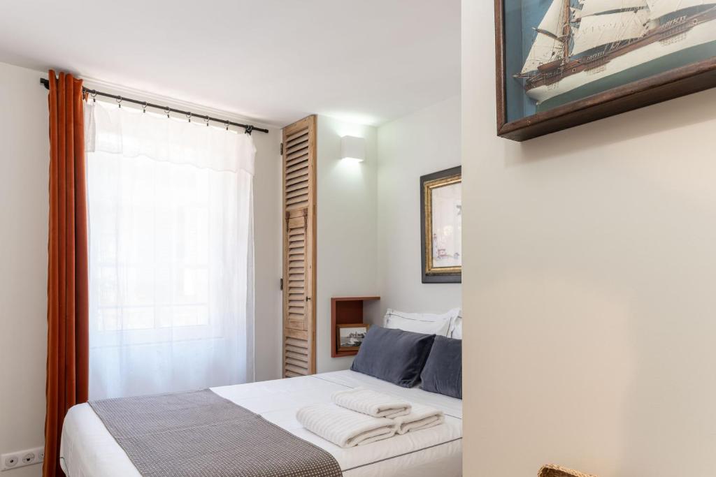 a bedroom with a bed and a picture of a ship at Les Petits Volets 2 à 100m de la mer in Antibes