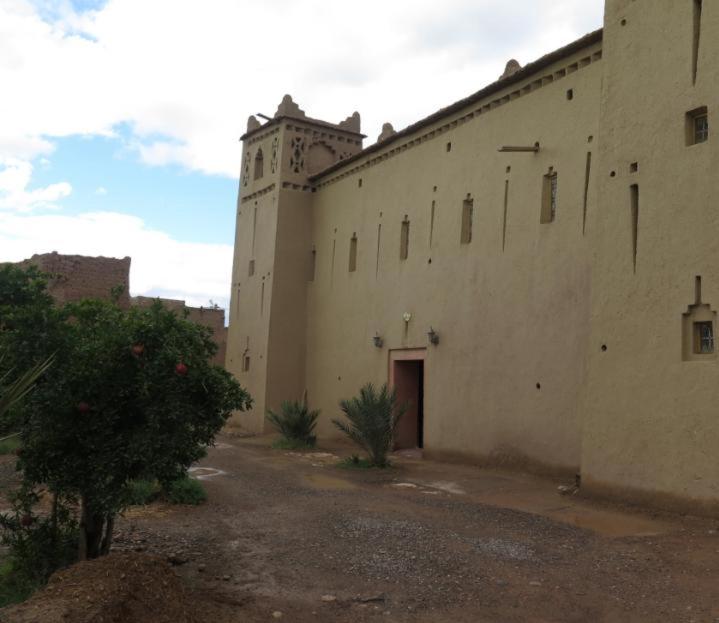 a large building with a clock tower on top of it at Kasbah d'hotes ayad in Moulay Brahim