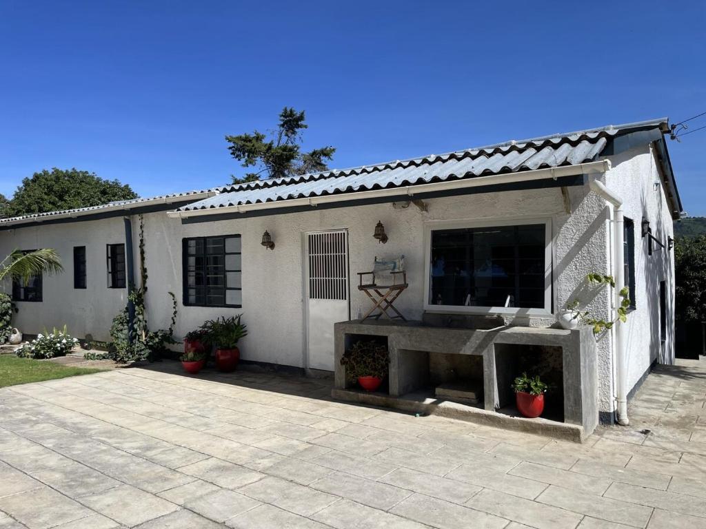 a white house with a patio in front of it at 3 bedroom house with a mountain view in Mbeya
