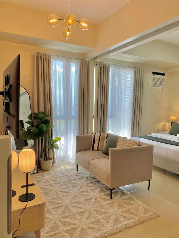 a living room with a couch and a bed at The SB Residences Luxury Executive Studio in Iloilo City