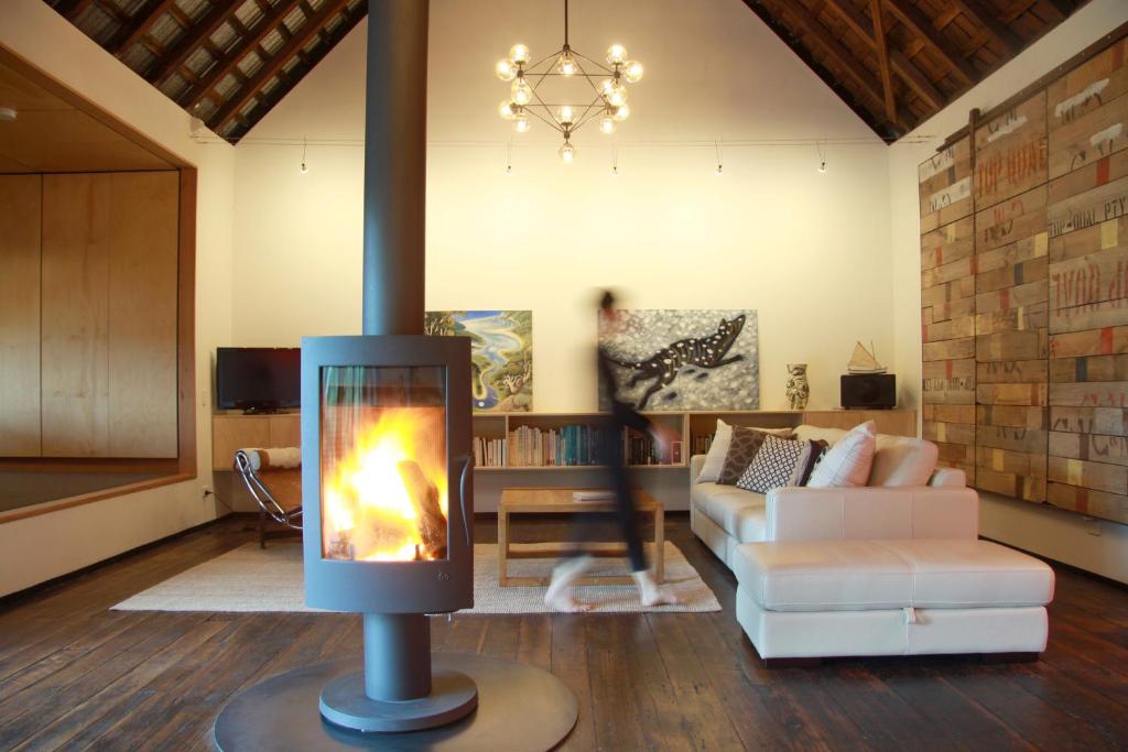 sala de estar con chimenea en el centro de la habitación en BIG.SHED.HOUSE, en Huonville