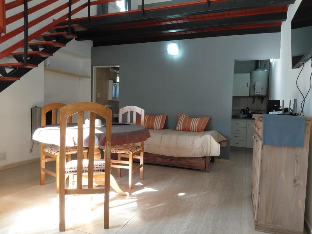 a living room with a table and a bed at Temporario Avenida in Rafaela