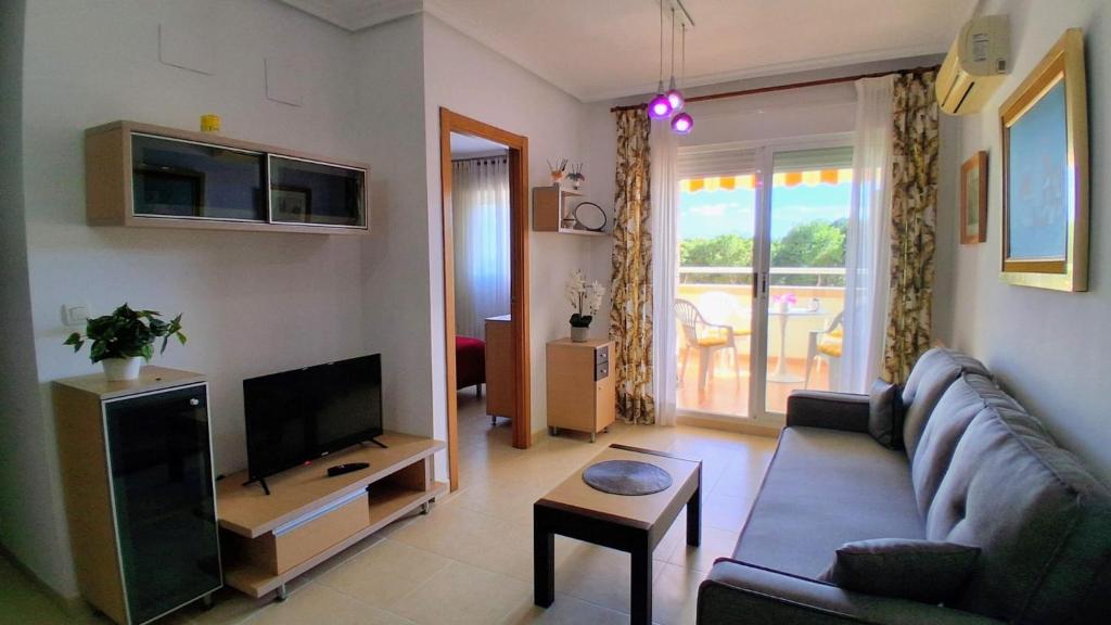 a living room with a couch and a television at Magic World Aguamarina in Oropesa del Mar