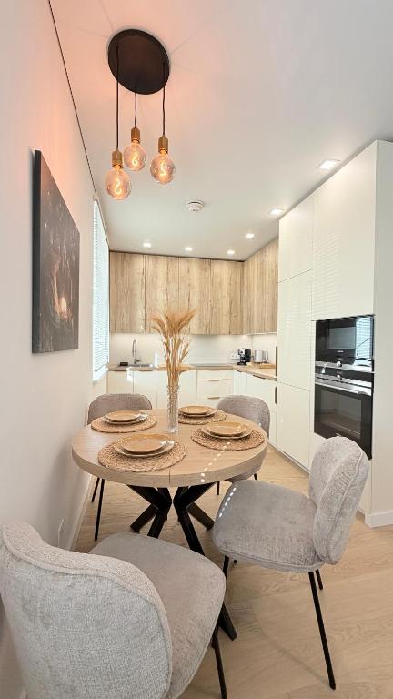 a kitchen and dining room with a table and chairs at Apartamentai Trakų centre in Trakai