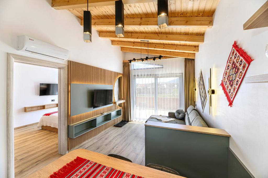 a living room with a couch and a tv at Selva Cabins in Zărneşti
