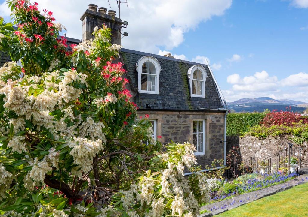 a stone house with flowers in front of it at Leven House Bed and Breakfast in Crieff