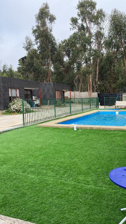 a yard with a fence and a swimming pool at Ritoque lodge in Vina del Mar