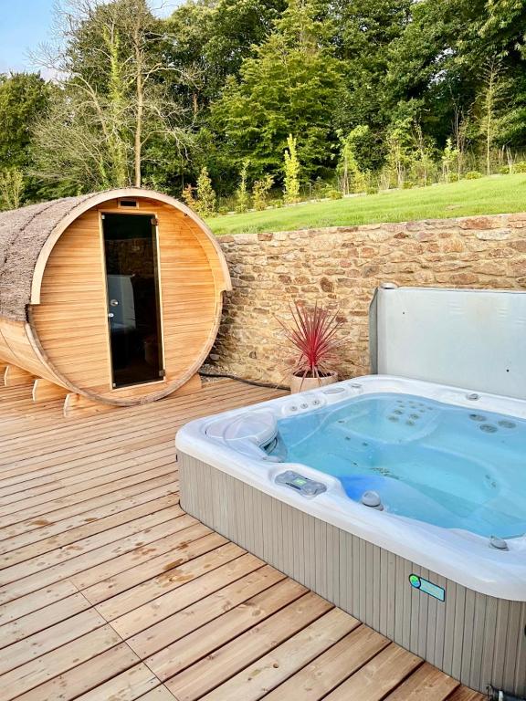 a hot tub sitting on a deck next to a building at Ty Toralann in Guipavas