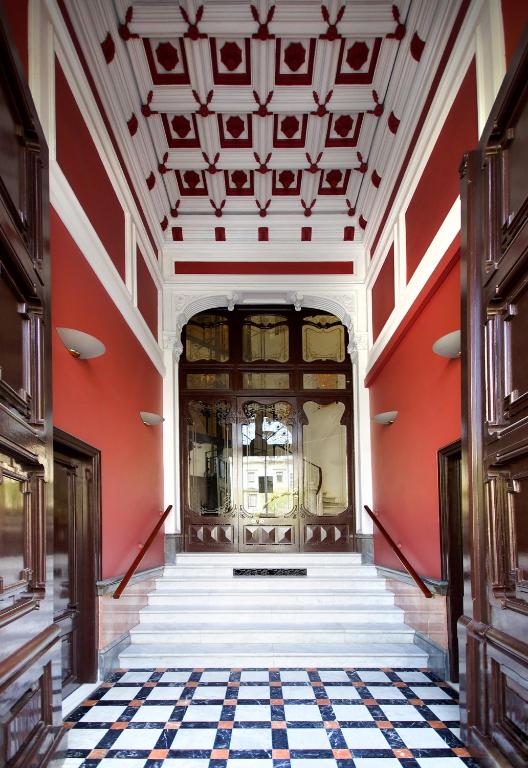 een hal van een gebouw met rode muren en trappen bij Casa Boutique Barcelona in Barcelona